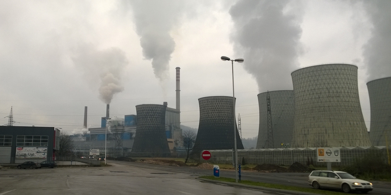 Lots of smoke coming out of stacks and cooling towers of the Tuzla lignite power plant.